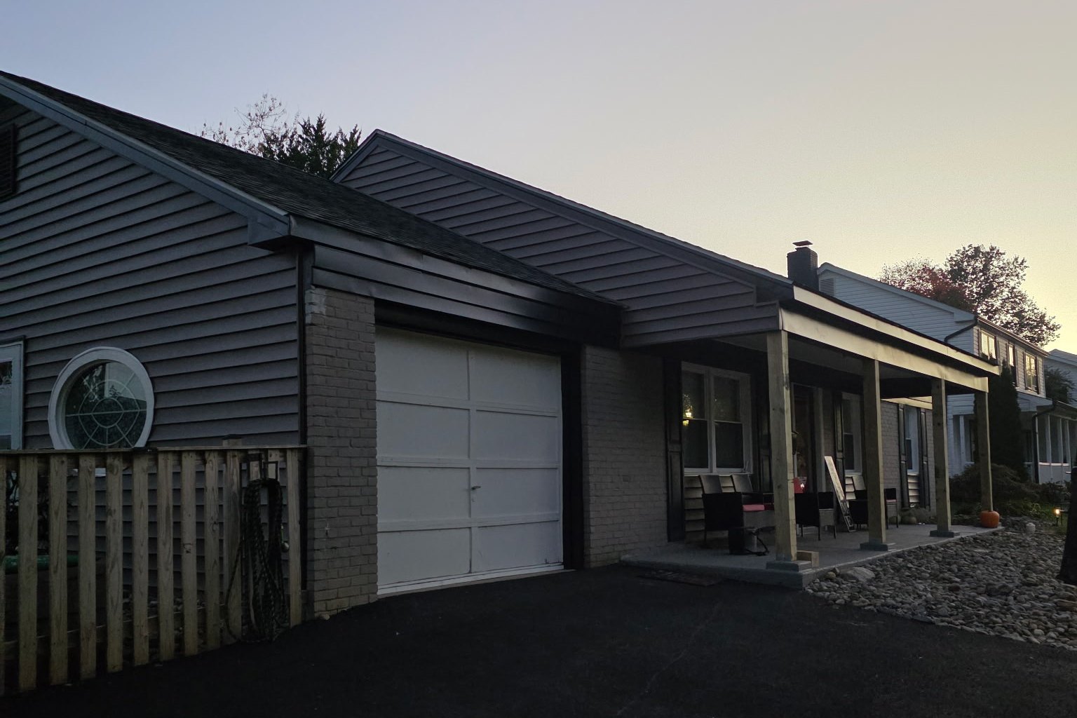 Siding replacement in Joppa, MD: CertainTeed Monogram siding, black metal fascia and rebuilt front porch at dusk by Next Phase Exterior