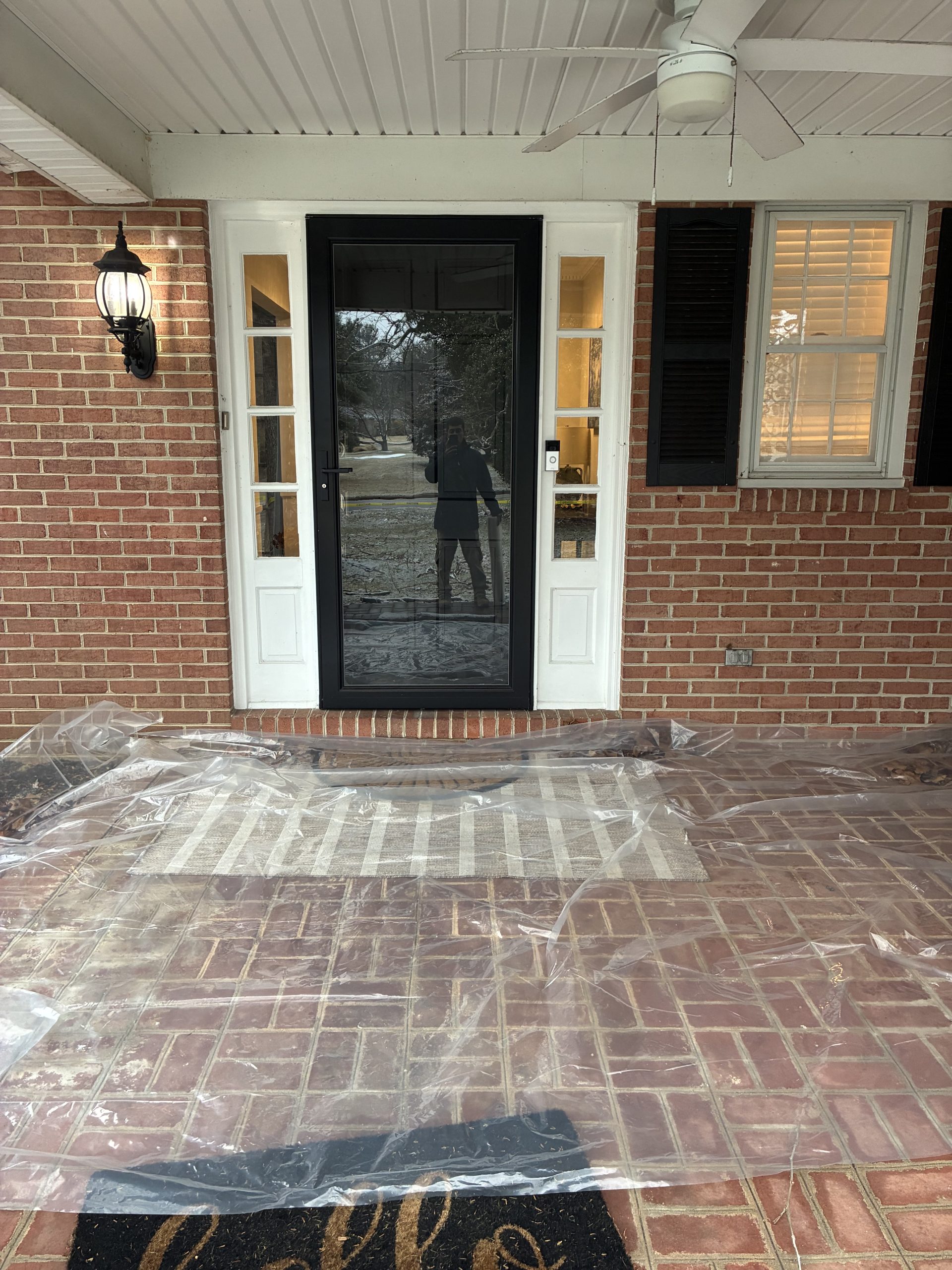 6-panel entry door with a storm door before replacement in Lutherville-Timonium, Maryland